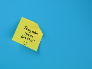 Obraz premium Stay calm you’ve got this message handwritten on yellow adhesive note on blue background. Perfect for concepts of mental health, workplace motivation, exam stress, and positive affirmation 