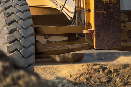 Road grader working at construction site for maintenance and construction of dirts and gravel road. Yellow motor grader. Heavy machinery and construction equipment for grading roads. Grader machine.