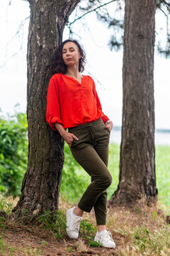 Woman Leaning Against Tree in Park