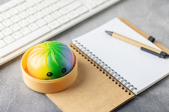Cute pastel dumpling squishy toy held on the table. Trendy anti stress toy