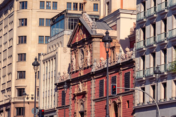 Obraz premium Historic church facade and surrounding architecture along Calle de Alcala in the center of Madrid Spain