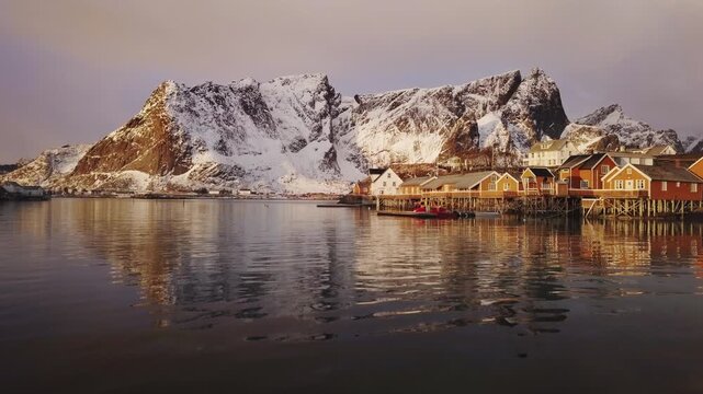 Stunning Lofoten winter scenery with traditional fisherman Rorbuer cabins at sunrise, Sakrisoy, village of Reine, Norway	