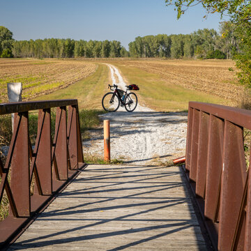 gravel touring bike on Steamboat Trace Trail converted from old railroad running across farmland and corn field near Peru, Nebraska