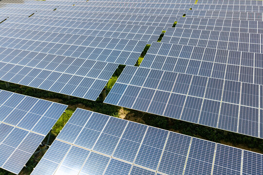 Drone view of large solar power plant and forested hills