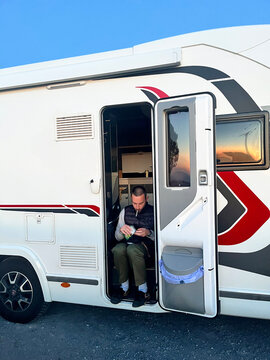 Traveler Rolling Cigarette on Camper Van Step