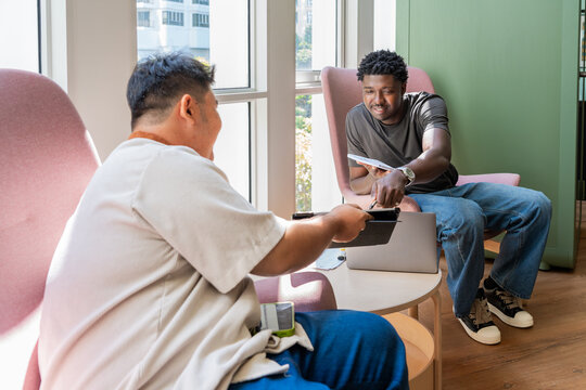 Two People Sharing a Task Inside a Modern Indoor Coworking Space