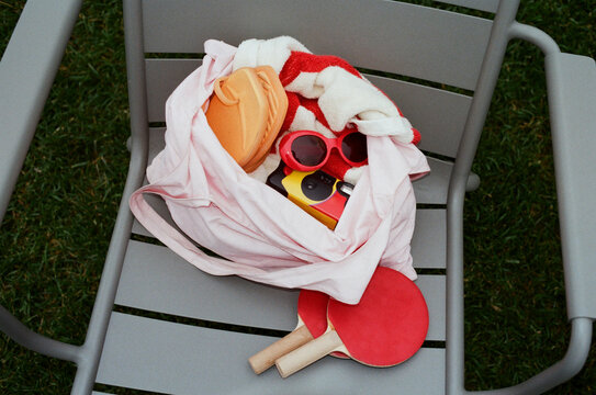 Bag with sandals, sunglasses, disposable camera and ping pong paddles