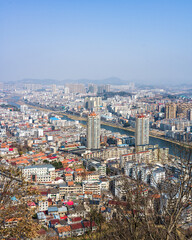 Naklejka premium Aerial perspective of sprawling valley city with winding river and dense architecture