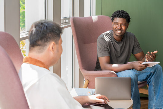 Man Talks to Another Colleague in a Modern Seating Area during the Day