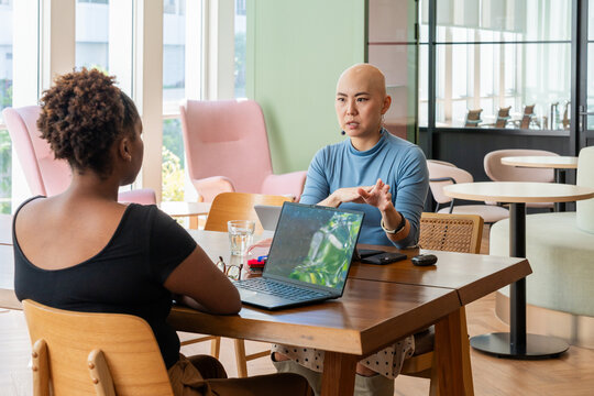 Two Women Discuss Ideas in a Modern Office Space During the Day