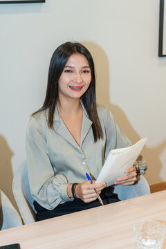 Entrepreneur Holds Paper and Pen During a Meeting at a Modern Office