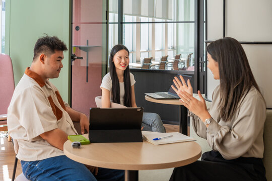 Group Discusses Ideas in Modern Office Setting During Afternoon