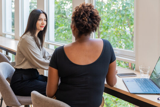 Women Talk in a Bright Workspace During the Day