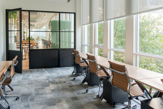 Work Space With Multiple Desks and Large Windows in an Office Building