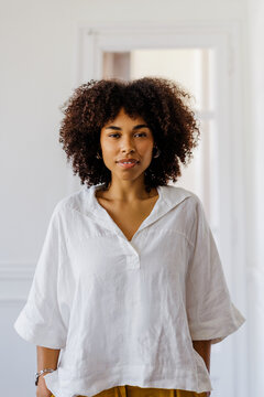 Woman with natural curly hair looking at camera against white space