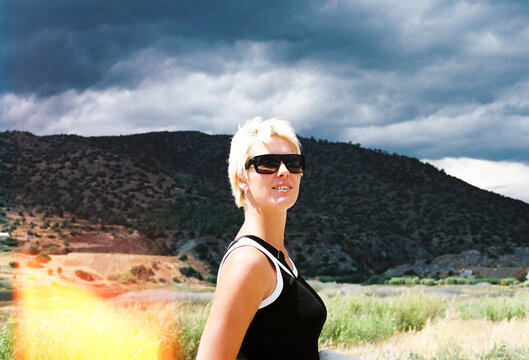 Woman Stands in Nature Under Cloudy Sky During Daytime