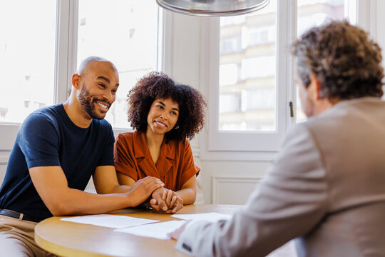 Couple smiling while meeting with financial advisor