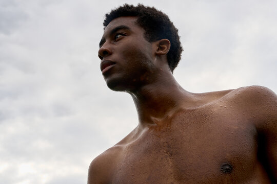 Man Standing Under Cloudy Sky With Water on Skin During Daytime