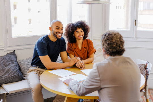 Couple consulting financial advisor discussing future investments