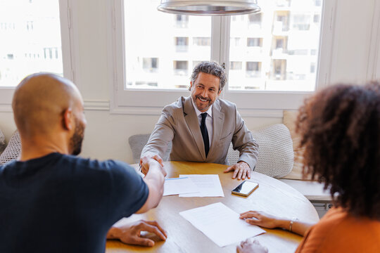 Financial advisor shaking hands with client during meeting