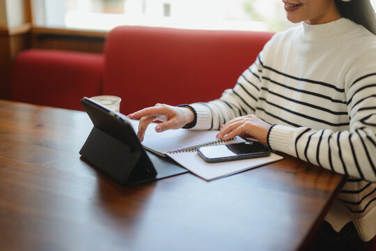 Woman using tablet in cafe for work or study