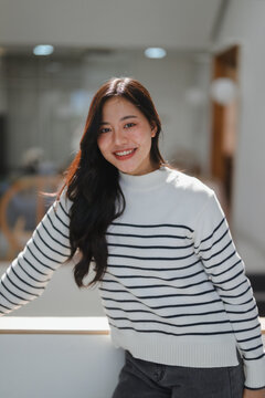 Happy young Asian woman smiling looking at camera