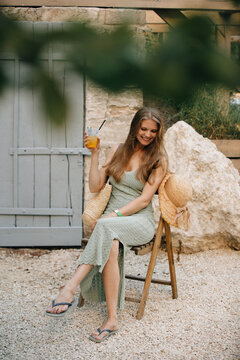 Woman enjoying summer holiday with refreshing drink outdoors