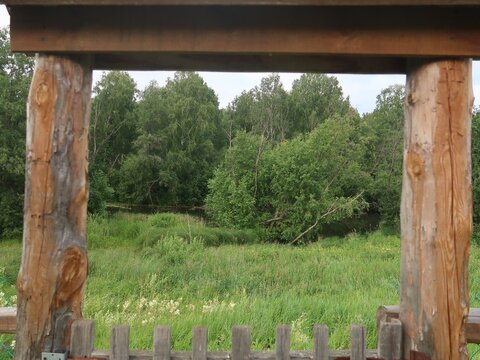 wooden fence near river and trees