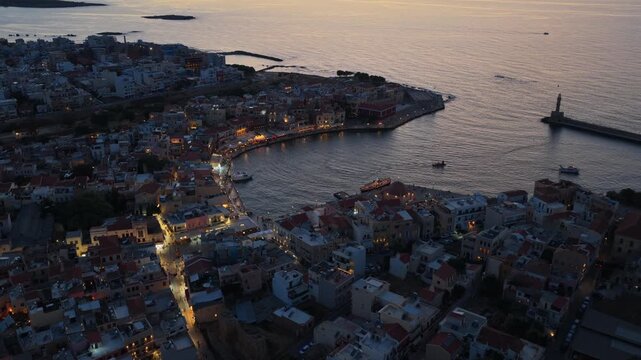 Aerial drone view of the Venetian harbor with its lighthouse breakwater and domed mosque, Chania, Greece