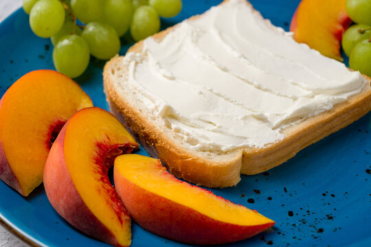 Breakfast plate with cream cheese toast, grapes, and peach slices