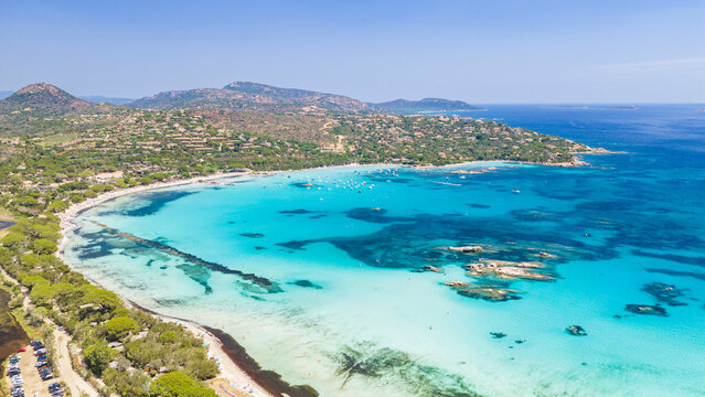 Aerial view of Plage de Santa Giulia on the southeast coast of Corsica, France, with white sand, shallow turquoise waters, Mediterranean vegetation, and a picturesque mountain backdrop
