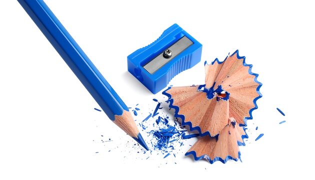 A vibrant blue colored pencil with a sharpener and shavings on a plain white background