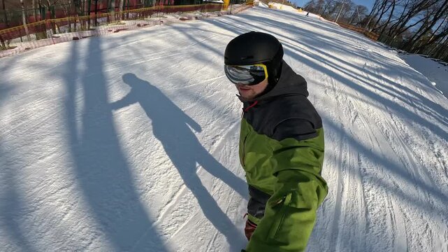 Snowboarder on snowy slope with ski lift