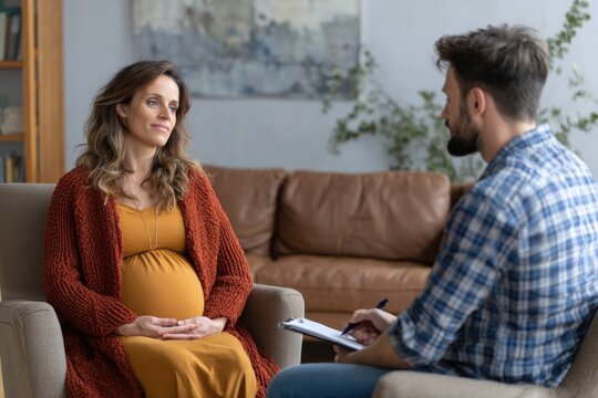 Pregnant woman in therapy session discusses feelings with male psychologist