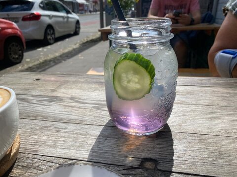 Erfrischende Holunderlimonade mit Gurke, Limette und Minze im Glas auf einem Caf&eacute;-Tisch. Sommergetr&auml;nk, Detox Water, Hydration, gesunder Lifestyle und Outdoor-Genuss.