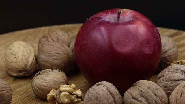 Red apple and walnuts rotating slowly.