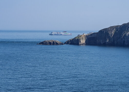 Anglesey, UK - 28 May 2026: A commercial Stena Line ferry sails the blue Irish Sea near North Stack on Holy Island in Anglesey Wales.