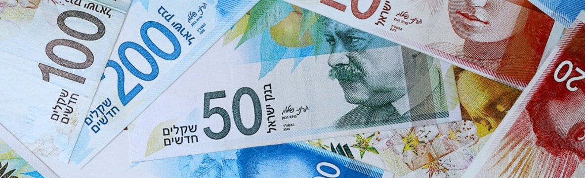 Israeli new shekel money bills in pile on table. Israel ILS currency cash close up