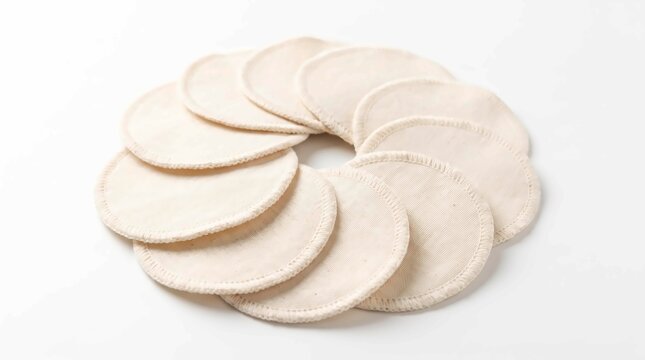 Several reusable organic cotton makeup remover pads arranged in a circular pattern on white background