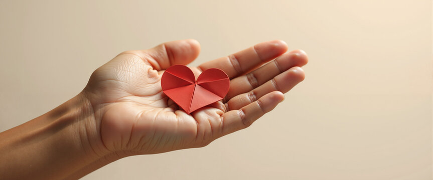 Open palm holding origami heart for emotional support and self care mental health campaigns