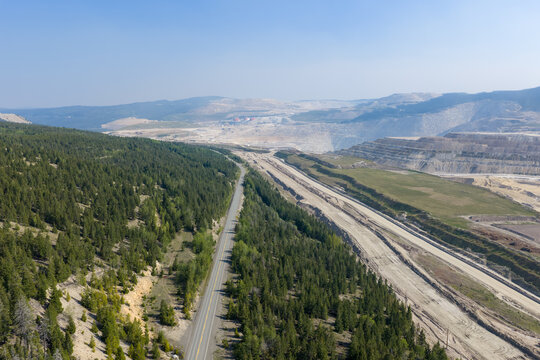 Aerial View of Road and Open-Pit Mine Beside Forested Landscape in British Columbia Canada
