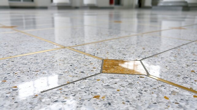 Close-up of a polished terrazzo floor with reflective surfaces and intricate geometric inlay patterns