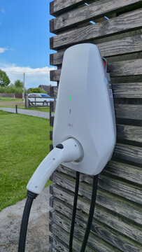 Wall Mounted Electric Vehicle Charging Station with EV Charging Cable Outdoors, Home Electric Car Charger, Sustainable Transportation and Clean Energy Concept