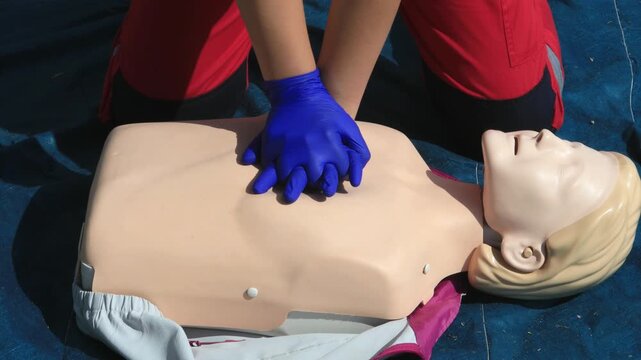 Paramedic Performing CPR Chest Compressions on a Training Manikin During First Aid and Resuscitation Training