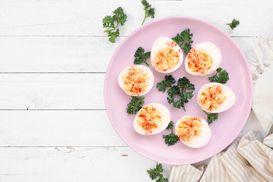Traditional deviled eggs. Above view table scene on a white wood background with copy space.