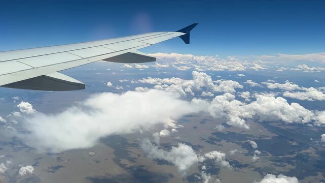 Airplane Wing Clouds Above Epic Utah Nevada Mountain Range. View Through Plane Window Passenger 747 Silver and Blue Tip. National Park Aerial Flight
