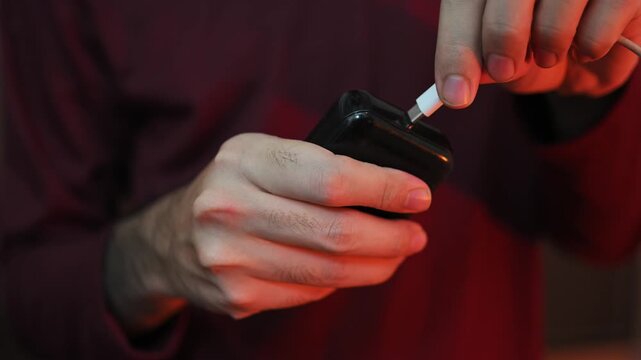Close Up of Hand Plugging Charging Cable into Electronic Device