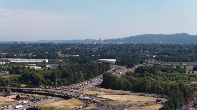 Aerial of highway interchange and distant view of downtown Portland Oregon with dense tree canopy from Vancouver Oregon