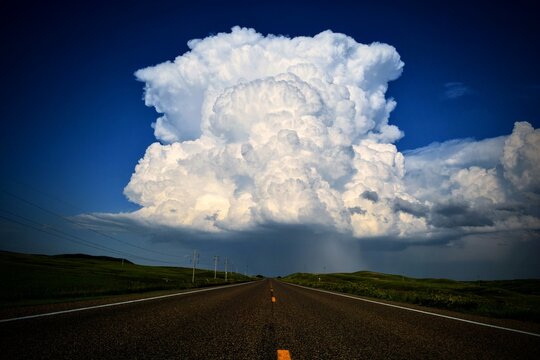 A massive Montana thunderstorm builds above a lonely highway