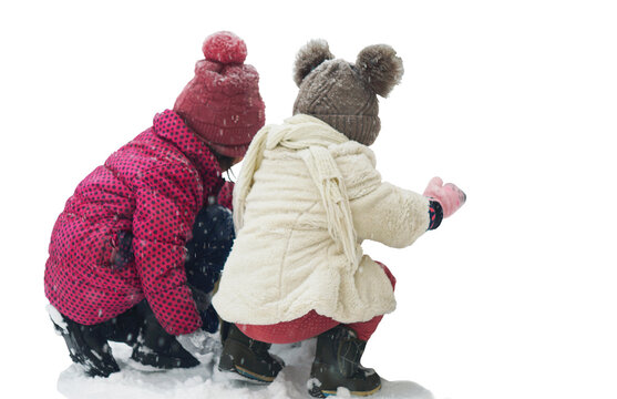 Two little girls are playing alone in the snow.